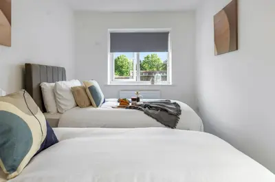 a room with two beds and a couch at Quiet St Helens Home Near Train Station, Free Parking and WiFi in Saint Helens