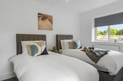 two beds sitting next to each other in a bedroom at Quiet St Helens Home Near Train Station, Free Parking and WiFi in Saint Helens