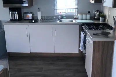 a kitchen with white cabinets and a sink at Seaside Retreat in Fleetwood in Fleetwood