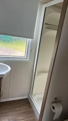 a bathroom with a glass shower door next to a sink at Heysham Coastal Escape Family 3-Bed Caravan in Heysham