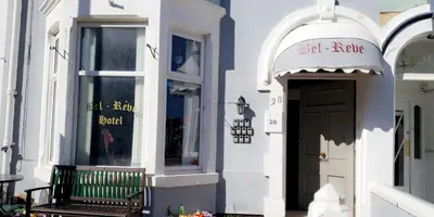 a white building with a bench in front of a door at Bel Reve Hotel in Blackpool