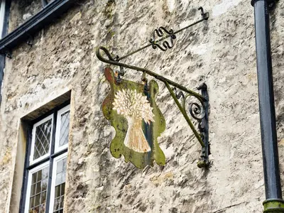 a sign on the side of a building at The Wheatsheaf at Beetham in Sandside