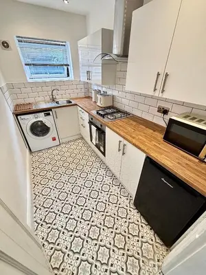 a small kitchen with a sink and a stove at Liverpool Escape - 5 min walk to LFC Stadium, Sleeps 8, free parking, newly renovated home in Liverpool