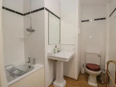 a white bathroom with a sink and a toilet at The Old Kitchen in Grange Over Sands