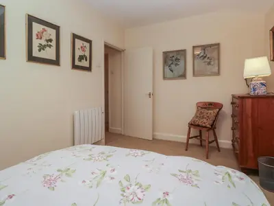 a bedroom with a bed and a chair at The Old Kitchen in Grange Over Sands