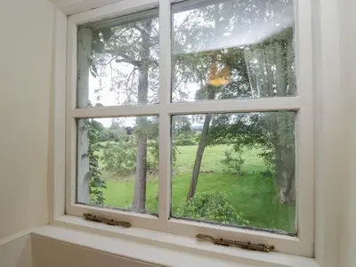 a window with a view of a green yard at The Old Kitchen in Grange Over Sands