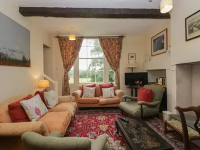 a living room with a couch and chairs and a fireplace at The Old Kitchen in Grange Over Sands