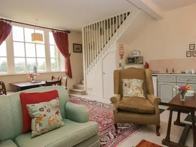 a living room with a couch and a chair at Huntsman's Cottage in Grange Over Sands