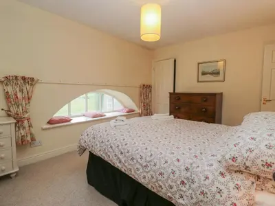 a bedroom with a bed and a window at Huntsman's Cottage in Grange Over Sands