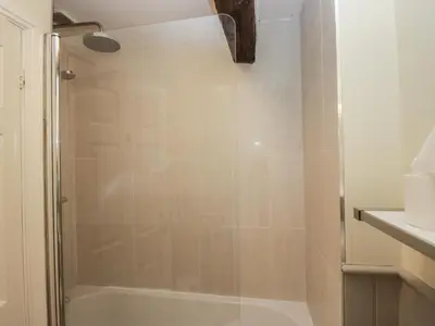 a bathroom with a shower with a tub at Huntsman's Cottage in Grange Over Sands