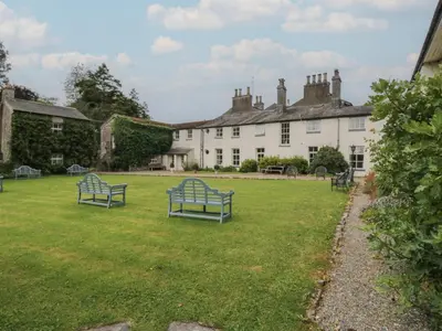 two blue benches in the yard of a house at Huntsman's Cottage in Grange Over Sands