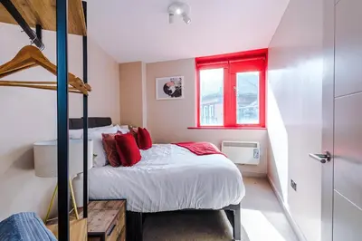 a bedroom with a bunk bed and a red window at Modern 2BR near Wigan Town Centre in Wigan