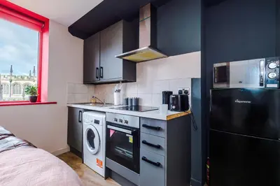 a kitchen with a stove and a washer and dryer at Modern 2BR near Wigan Town Centre in Wigan