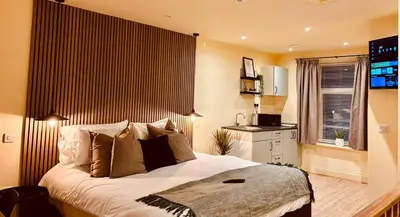 a bedroom with a large bed and a kitchen at 8 Parker Street in Lancaster