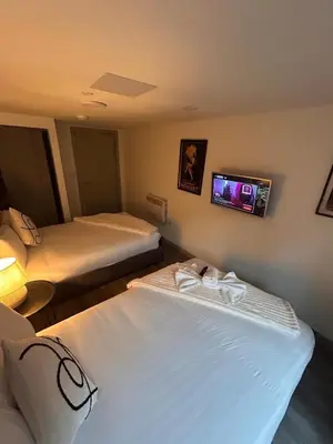 two beds in a room with a tv on the wall at Modern Duplex Apartment - Liverpool City Centre in Liverpool