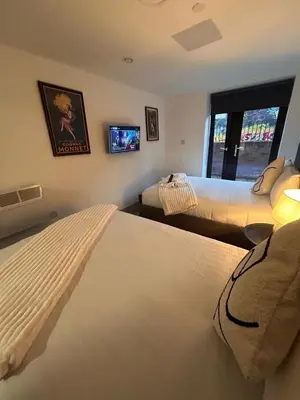 a bedroom with two beds and a tv on the wall at Modern Duplex Apartment - Liverpool City Centre in Liverpool