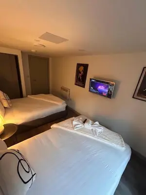 two beds in a room with a tv on the wall at Modern Duplex Apartment - Liverpool City Centre in Liverpool