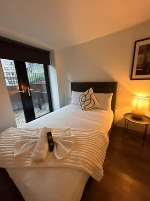 a bedroom with a large white bed with a robe on it at Modern Duplex Apartment - Liverpool City Centre in Liverpool