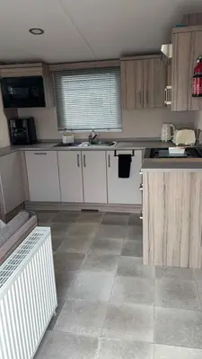 a kitchen with white cabinets and a tile floor at B10 - The Escape Pod in Heysham