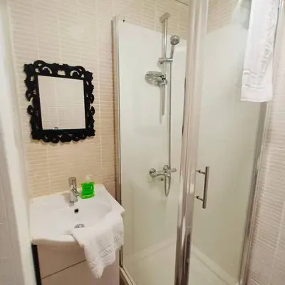 a bathroom with a sink and a shower with a mirror at Bold Street Studio V in Liverpool