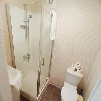a white bathroom with a shower and a toilet at Bold Street Studio V in Liverpool