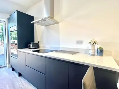 a kitchen with blue cabinets and a sink at Mode Apartments St Annes in Lytham St Annes