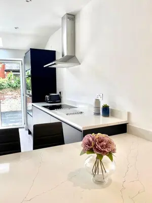 a kitchen with a vase with a flower on a table at Mode Apartments St Annes in Lytham St Annes
