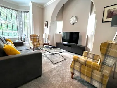 a living room with a couch and a tv at Mode Apartments St Annes in Lytham St Annes