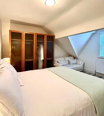 a bedroom with a white bed and a couch at Mode Apartments St Annes in Lytham St Annes