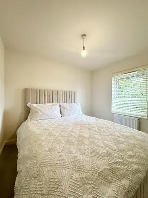 a bedroom with a bed with a white comforter and a window at Charming 1 Bedroom with Private Bath in Woodplumpton
