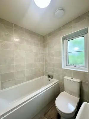 a bathroom with a white tub and a toilet and a window at Charming 1 Bedroom with Private Bath in Woodplumpton