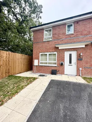 a brick house with a white door and a driveway at Charming 1 Bedroom with Private Bath in Woodplumpton