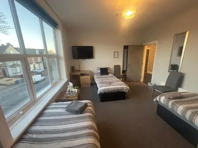 a room with two beds and a large window at The Prince Alfred Rooms in Liverpool