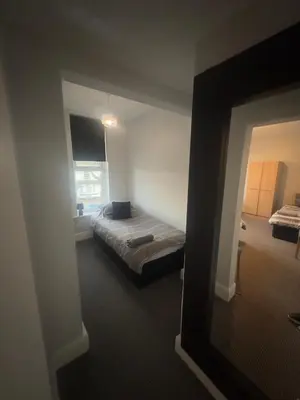 a bedroom with a bed in a room with a mirror at The Prince Alfred Rooms in Liverpool