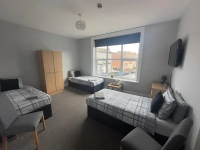 a room with a bedroom with a bed and a couch at The Prince Alfred Rooms in Liverpool
