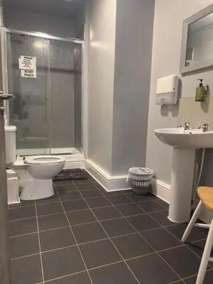 a bathroom with a shower and a toilet and a sink at The Prince Alfred Rooms in Liverpool