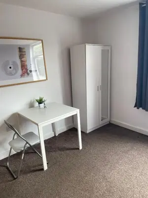 a white table and a chair in a room at Babo accommodation in Bolton