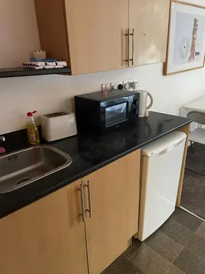 a kitchen with a sink and a microwave on a counter at Babo accommodation in Bolton