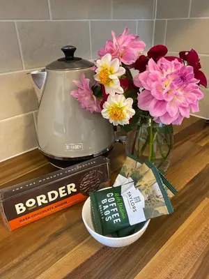a counter with flowers and a blender and a vase of flowers at Yealand Redmayne 3 bed Home in Beetham