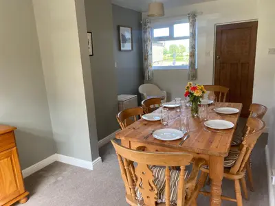 a dining room with a wooden table and chairs at Yealand Redmayne 3 bed Home in Beetham