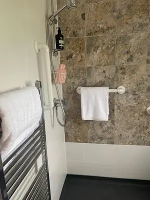 a bathroom with a shower with a white towel at Yealand Redmayne 3 bed Home in Beetham