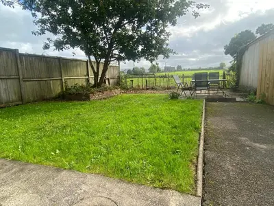 a yard with a bench and a tree at Yealand Redmayne 3 bed Home in Beetham