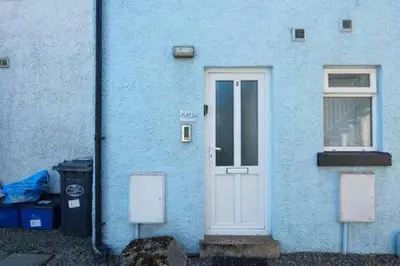 a blue house with a white door and a window at 2 Bed Flat in Ulverston in Ulverston