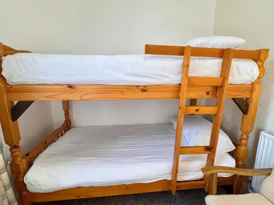 two bunk beds in a room with a ladder at Kendal Hotel in Blackpool