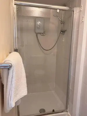a shower with a glass door in a bathroom at Kendal Hotel in Blackpool