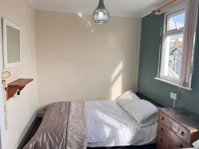 a small bedroom with a bed and a window at Kendal Hotel in Blackpool