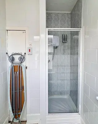 a shower with a glass door in a bathroom at Kendal Hotel in Blackpool