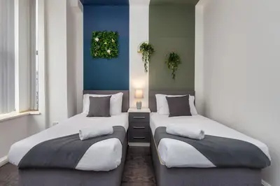 two beds sitting next to each other in a room at Charles Alexander Short Stay - South Pier Apartments in Blackpool