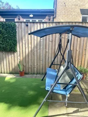 a swing chair in a yard with a fence at Valentinez Properties - Apart Hotel with a garden in Liverpool in Liverpool