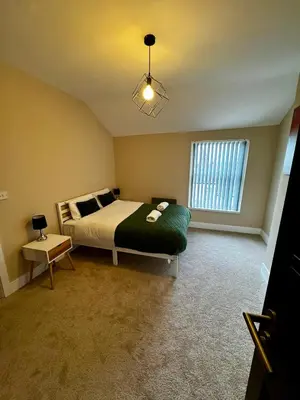 a bedroom with a large bed and a window at Stylish and Bright 1 Bedroom Flat in Wallasey
